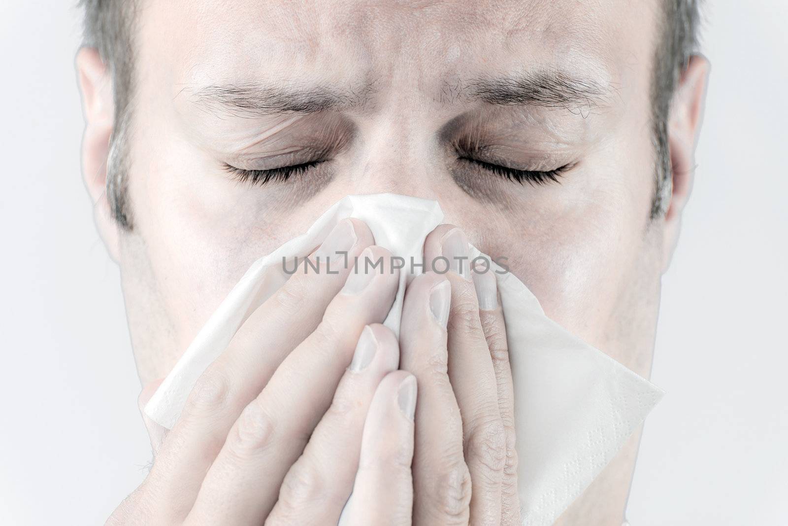 Ill man with tissue is sneezing by w20er