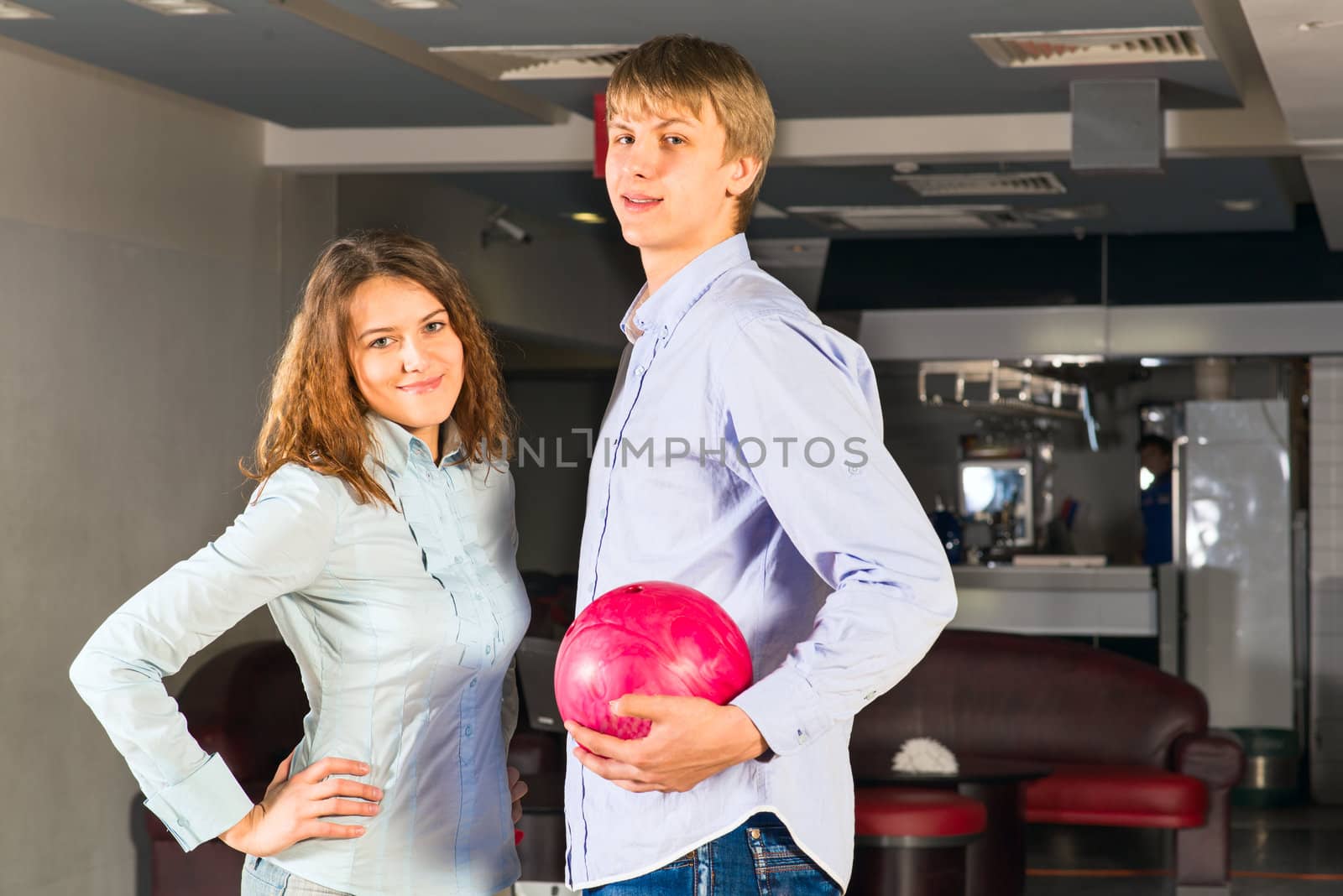 guy hugs her friendgirl, playing together in bowling