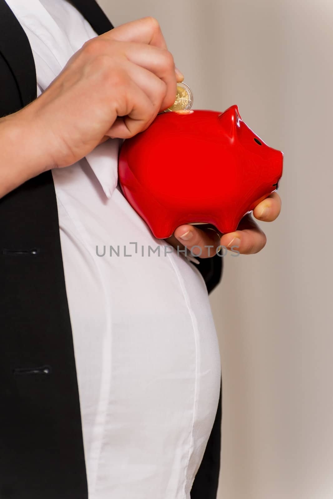 Pregnant Business Woman throws two euro in piggy bank
