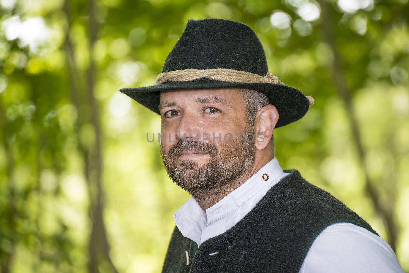 Man with Bavarian traditional black hat iin forest
