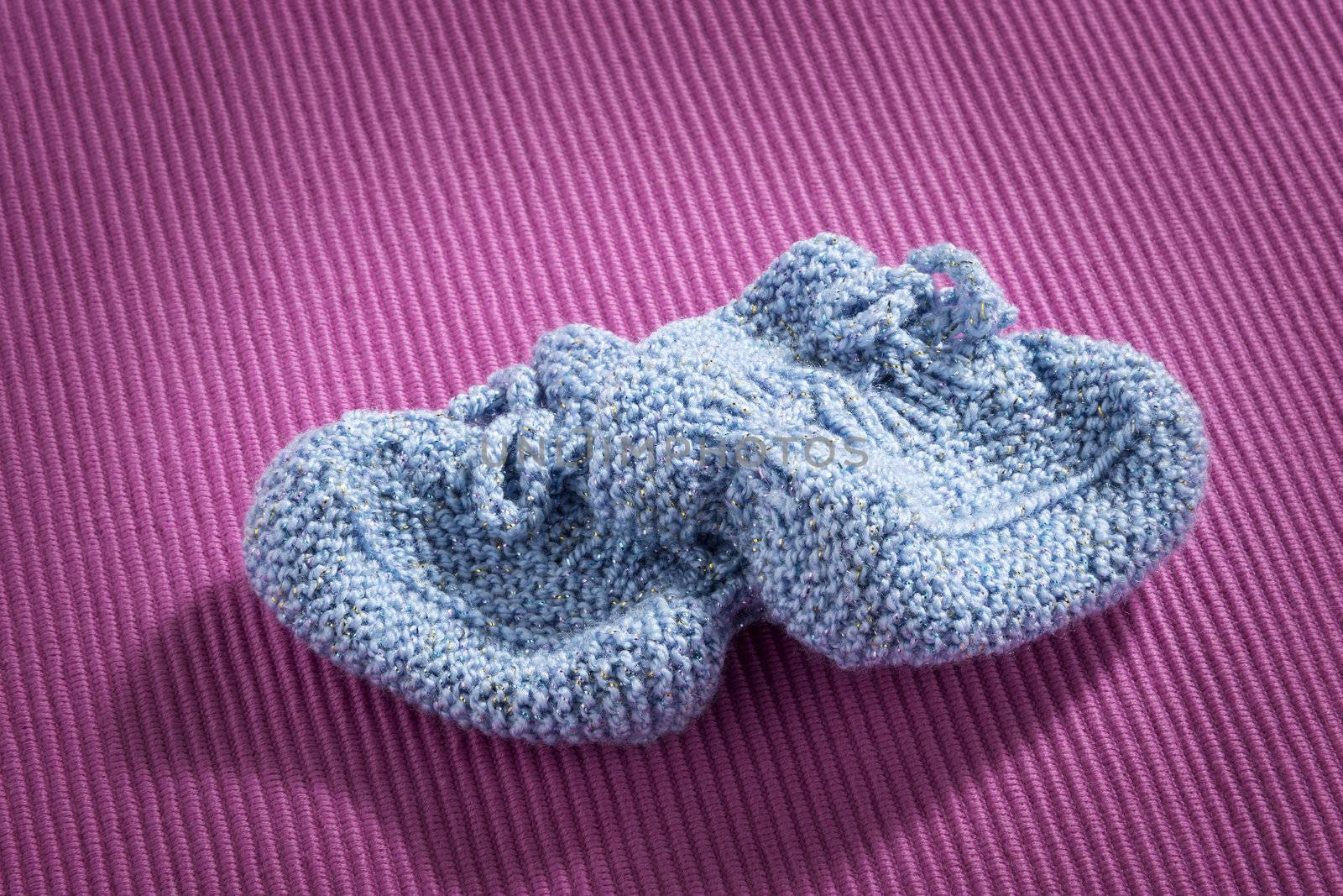 Blue baby socks on pink background