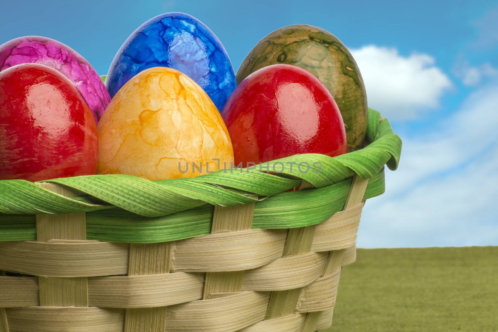 Colored easter egg basket with blue sky and white clouds