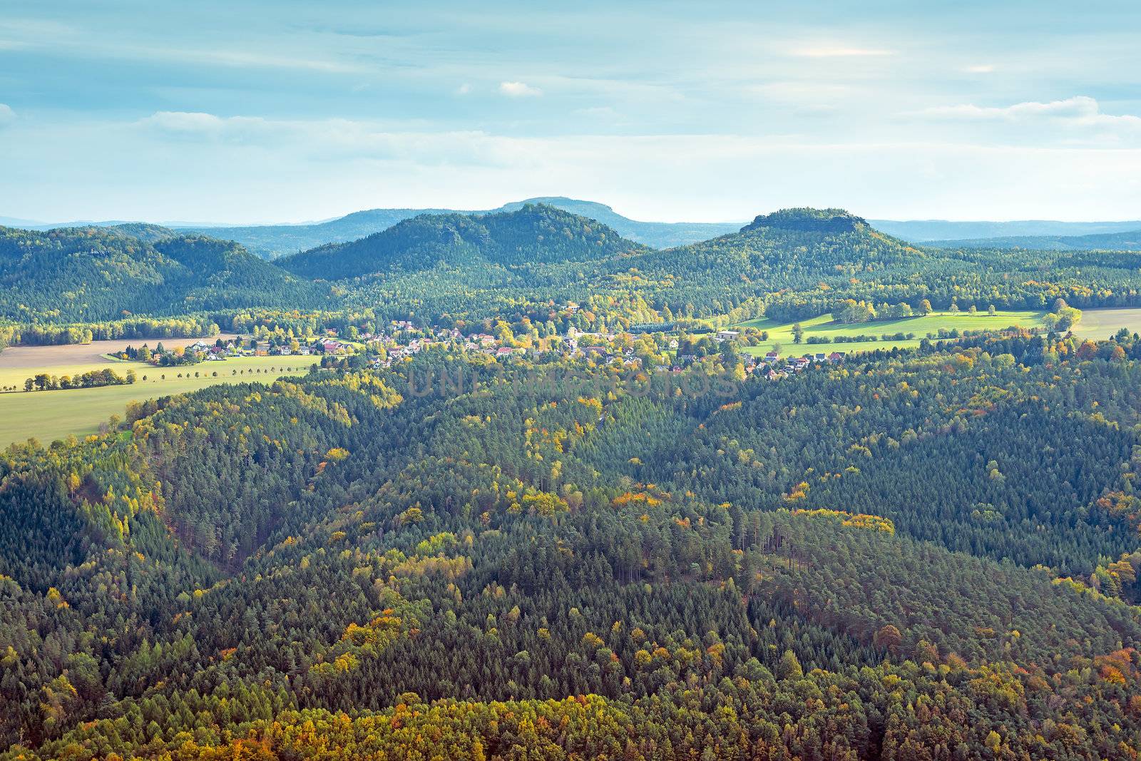 hills in saxony switzerland with forest, village in autumn