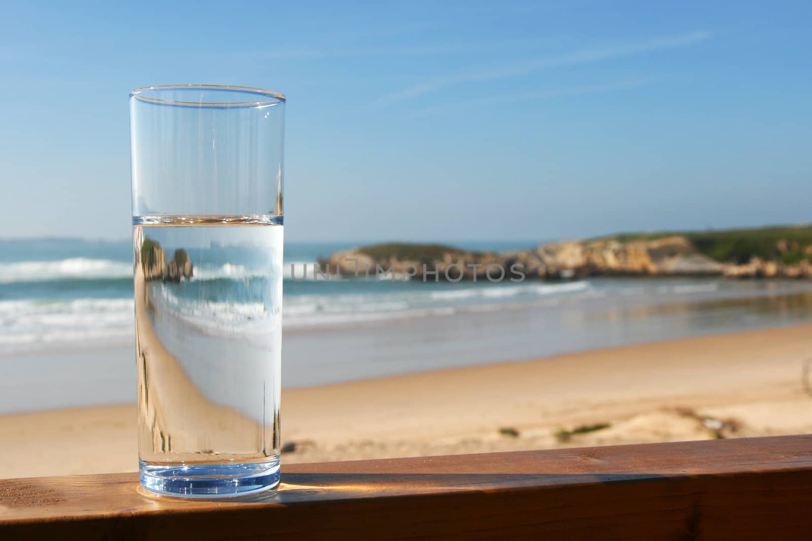 water in glass with view on ocean by nataliamylova