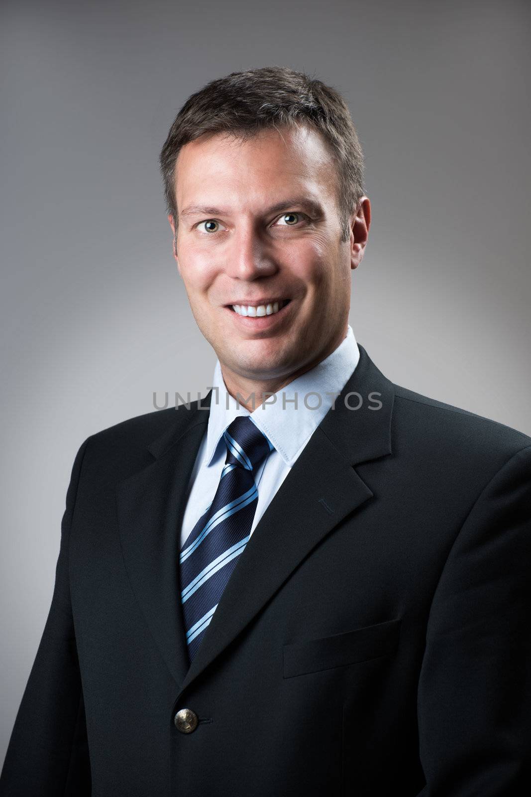 Portrait of a business man in dark suit and grey background