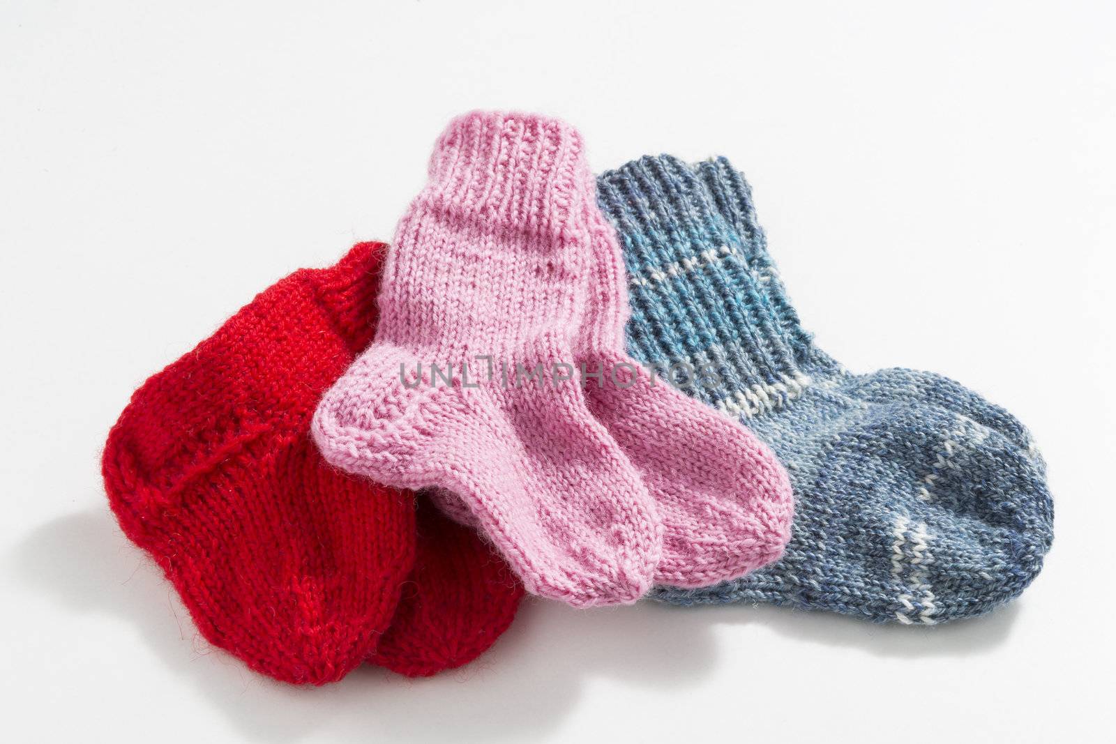 Hand-knitted baby socks on a white background
