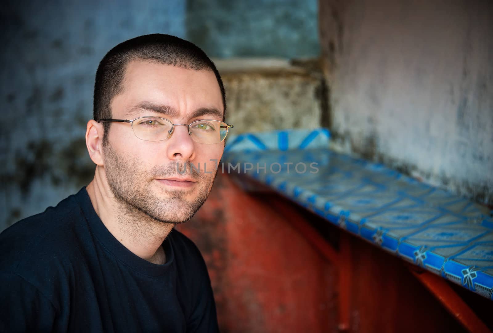 Young unshaved man portrait, grungy background with vignette