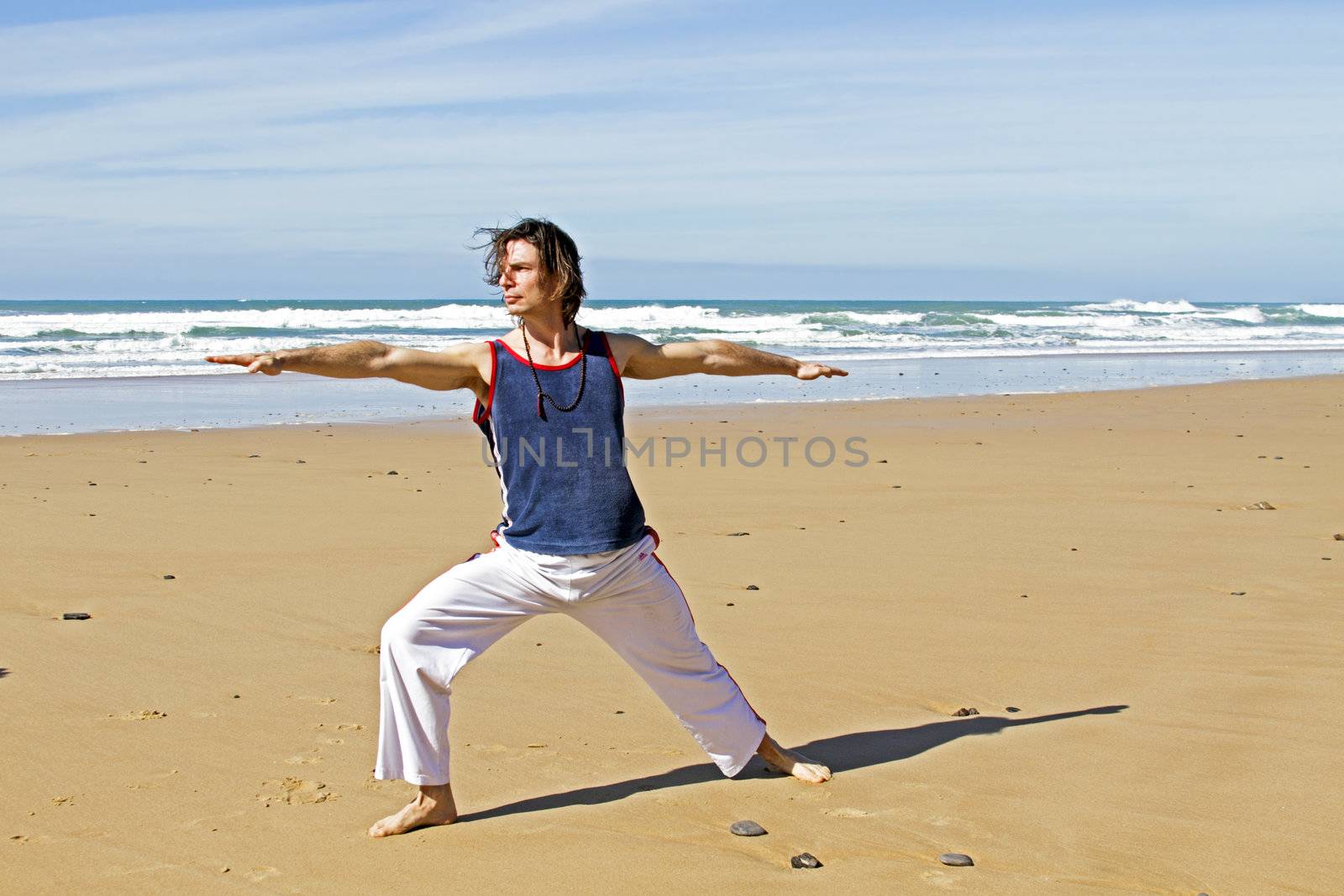 Man doing yoga exercises at the beach