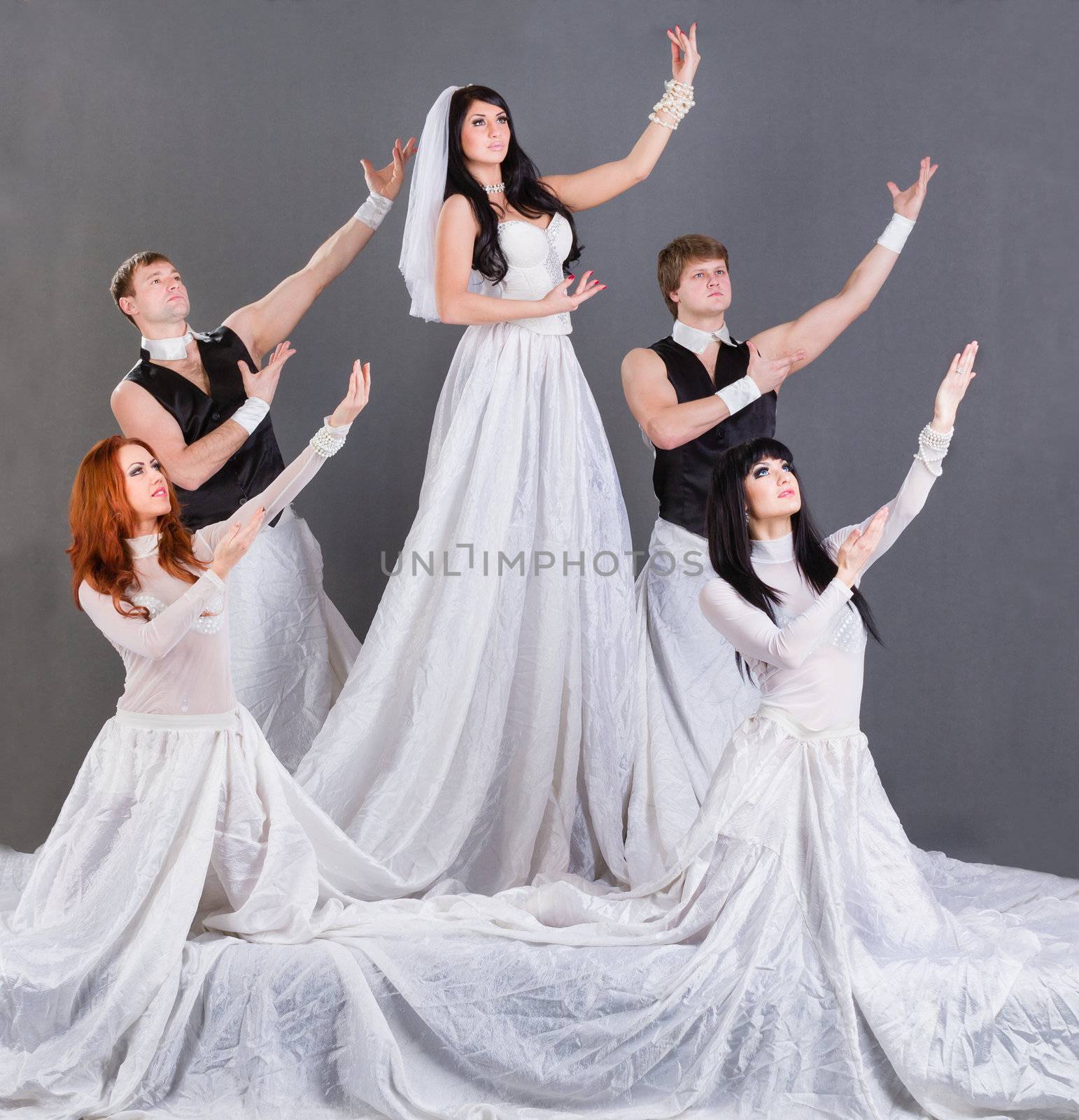 Actors in the wedding dress dancing. On a gray background in full length.