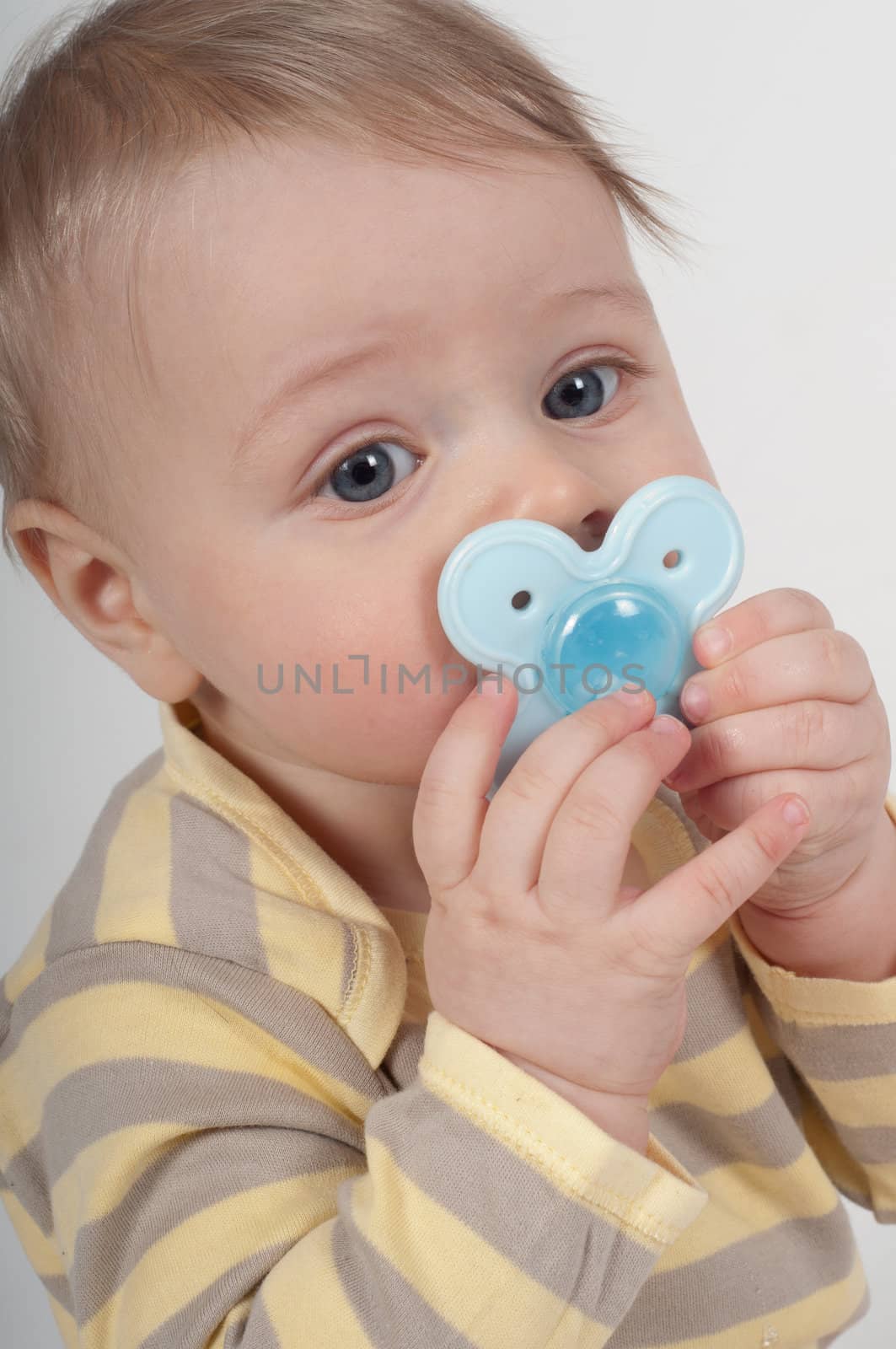 Little cute boy in striped top with teething ring