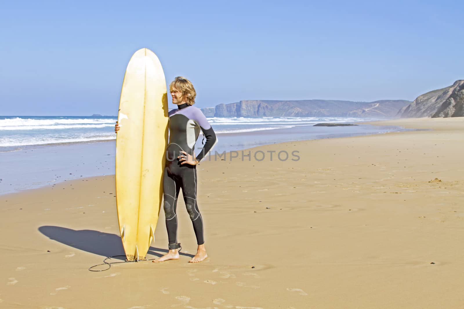 Surfer with his surfboard at the beach by devy