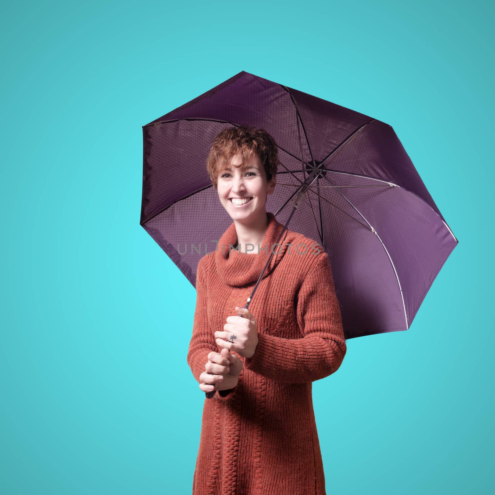 beautiful woman with sweater and umbrella on blue background