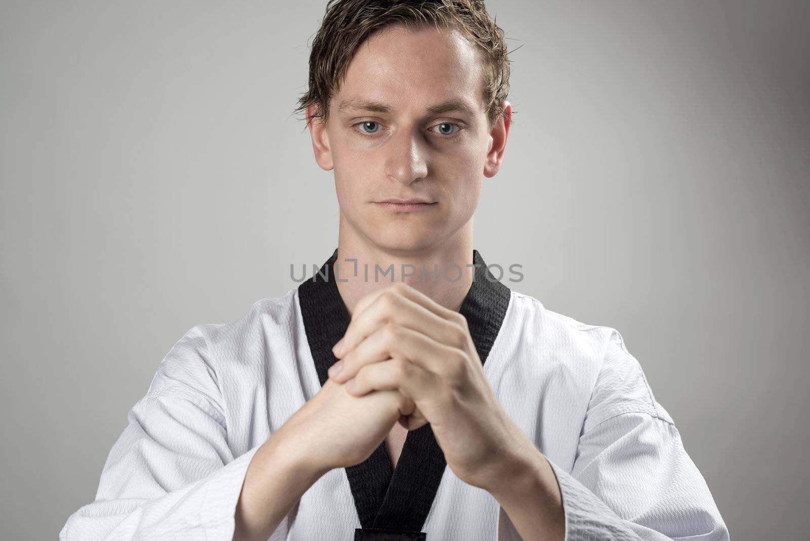 Taekwon-Do champoin on a grey background and and is preparing for the fight