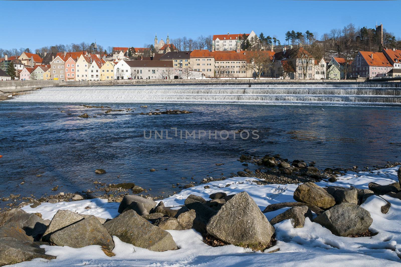 View to a small town in Germany in winter with river and stones in the foreground