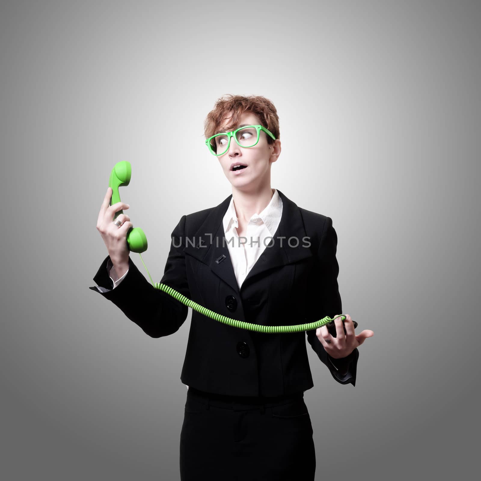 surprised business woman with phone on gray background