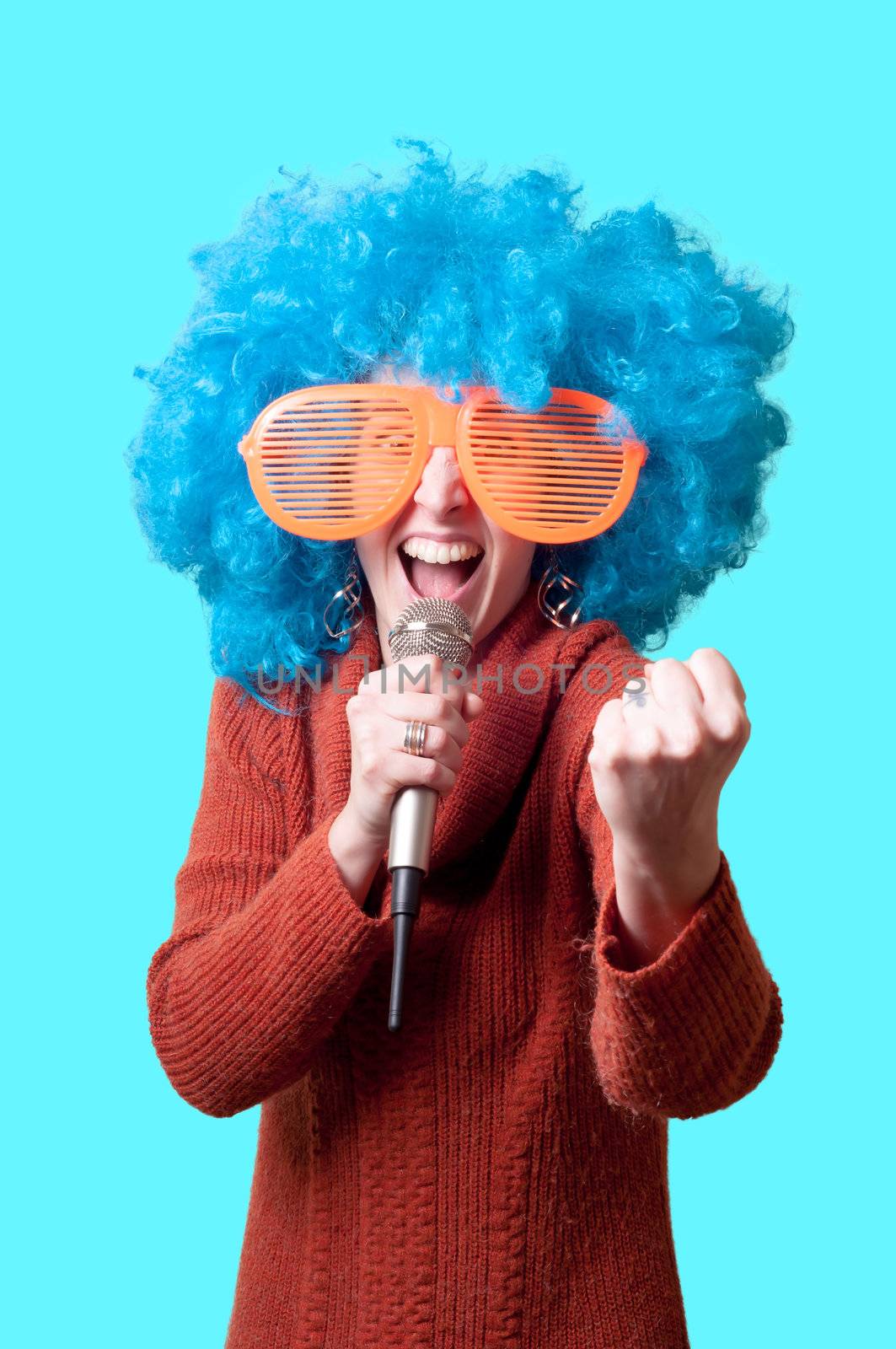 beautiful girl with curly blue wig and turtleneck on bllue background