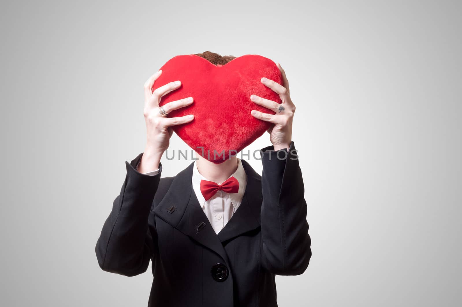 elegant businesswoman with heart pillow on gray background