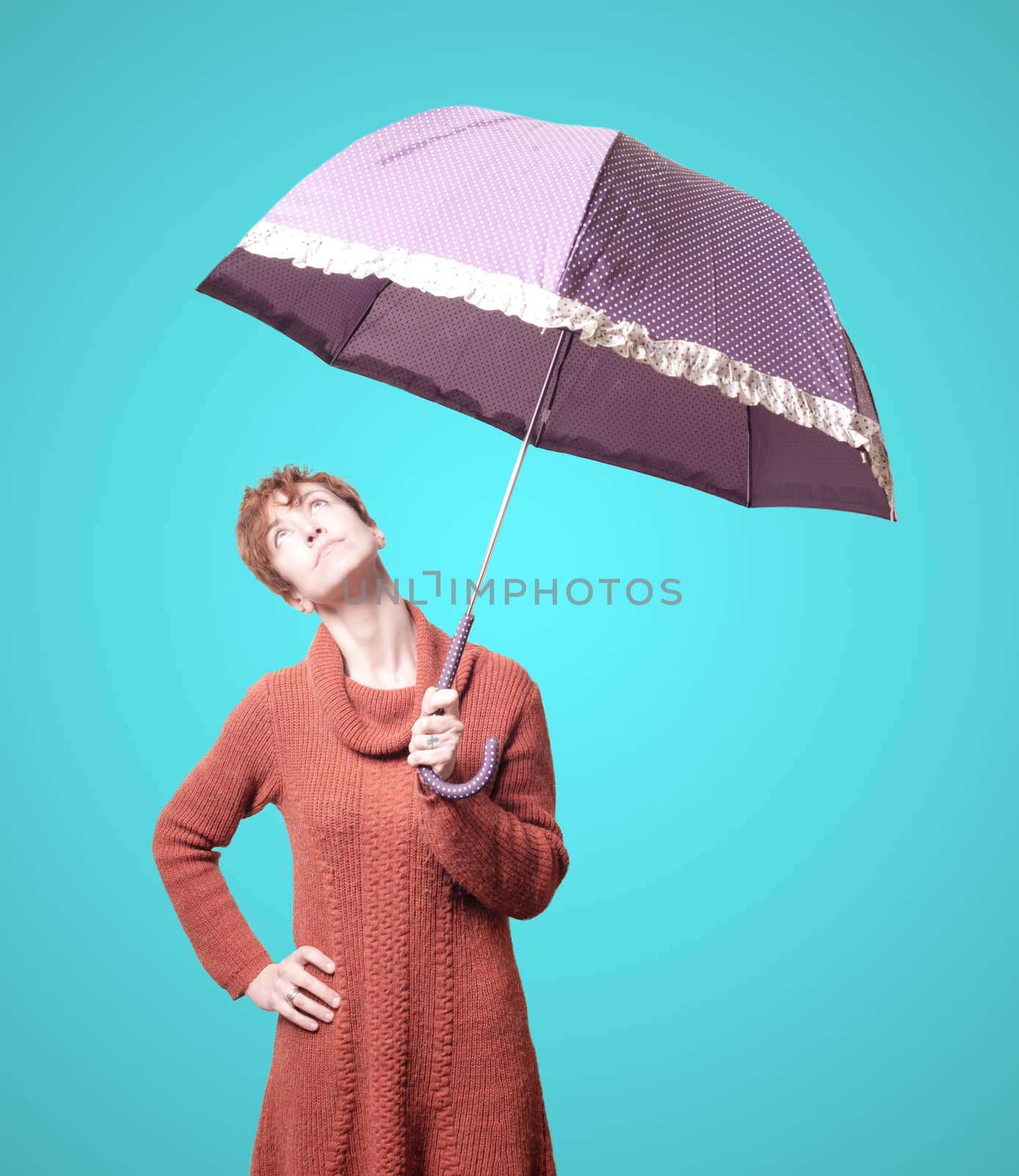 beautiful woman with sweater and umbrella on blue background