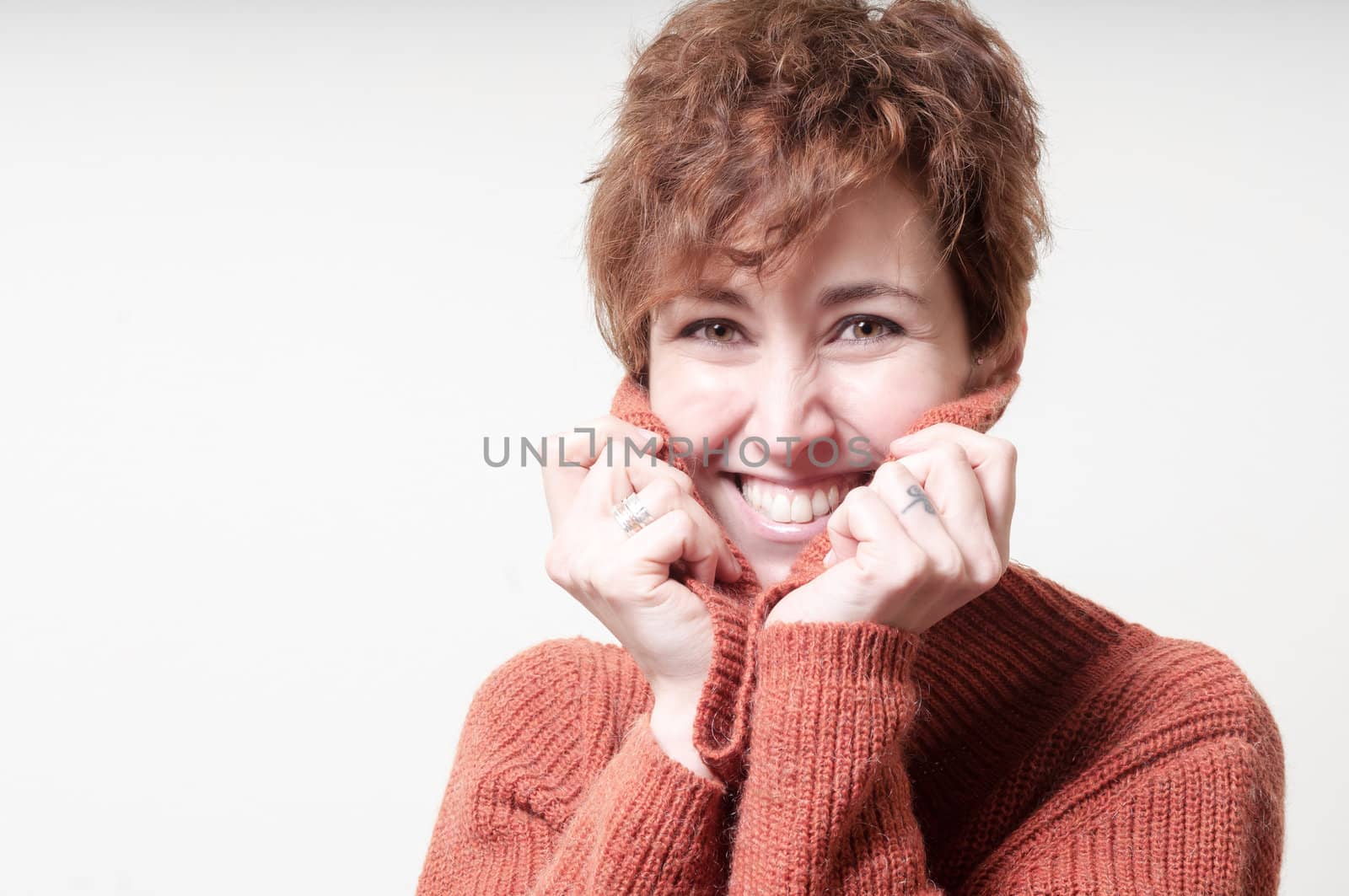 smiling short hair girl cold with orange sweater on white background