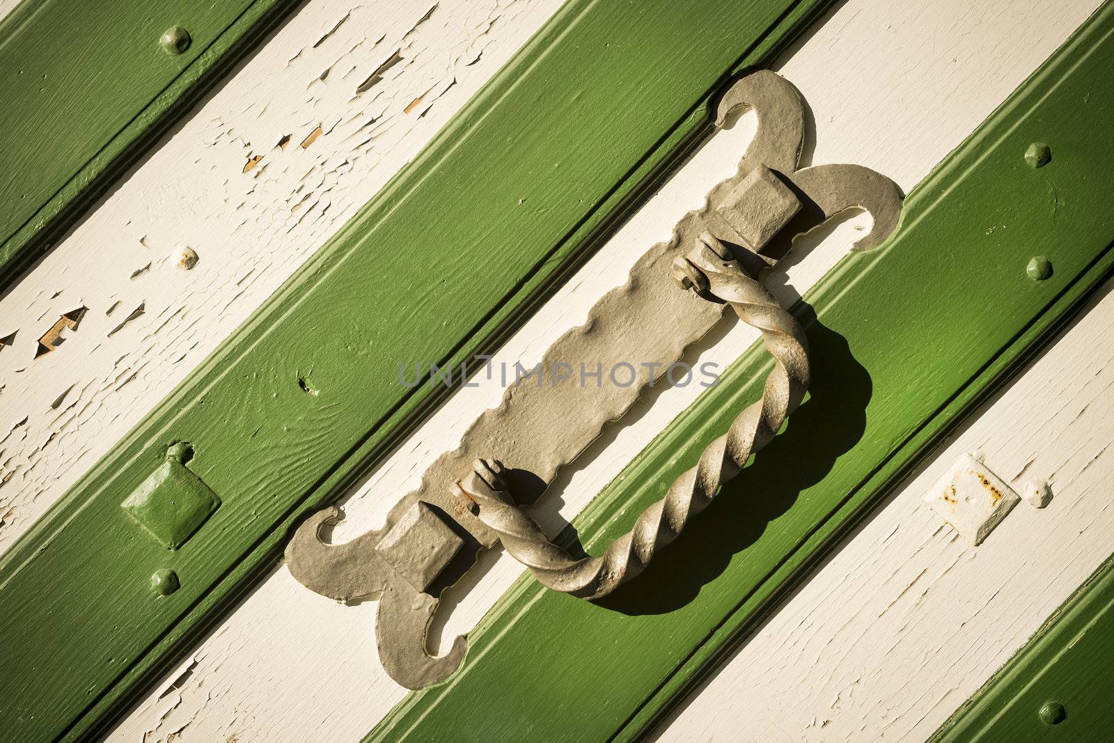 Metal handle on white green medieval gate