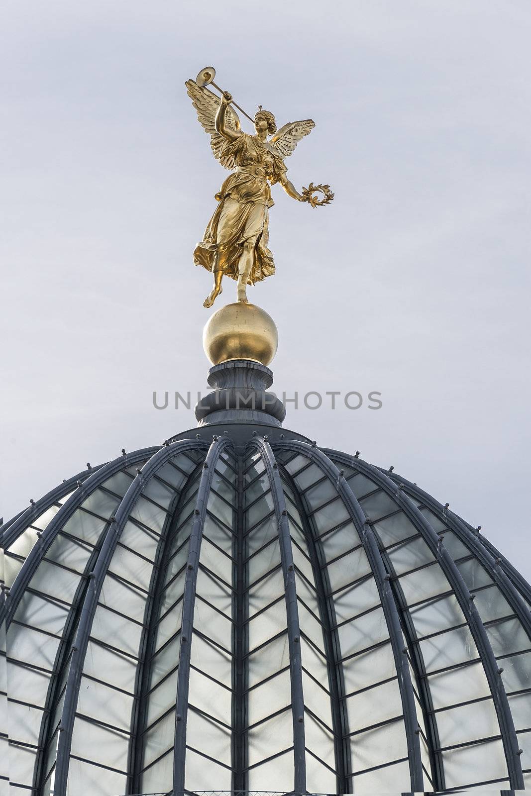 Golden angel with trumpet on the top of historic house in Dresden