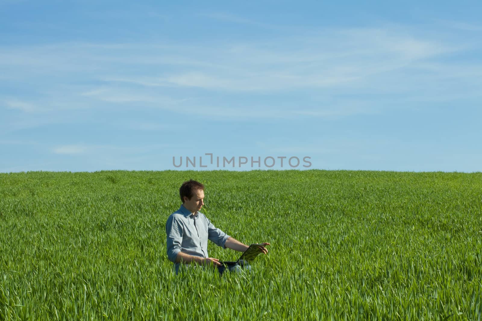 young man using laptop in the field