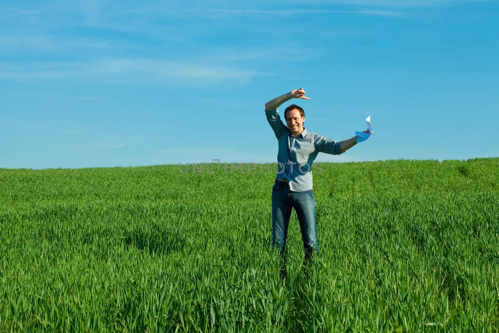 young man throwing a paper in the green field