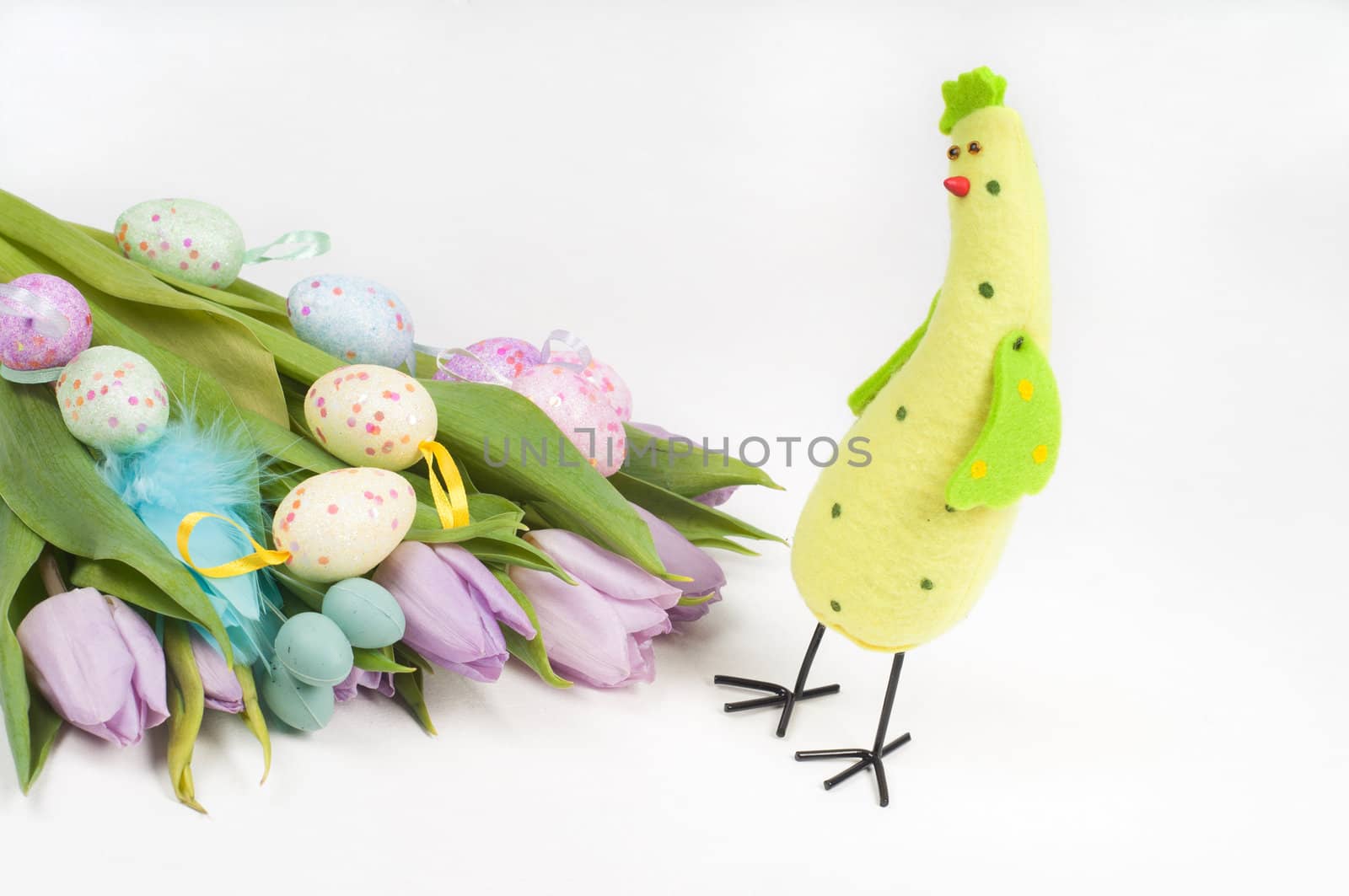Easter chicken with eggs and tulips on light background