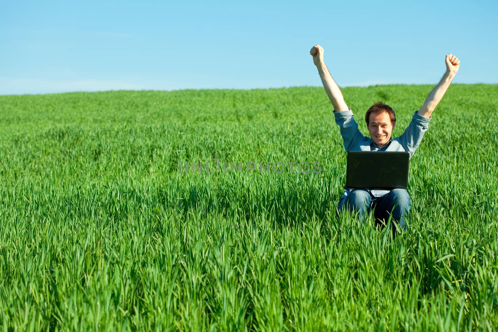 young man using laptop in the field