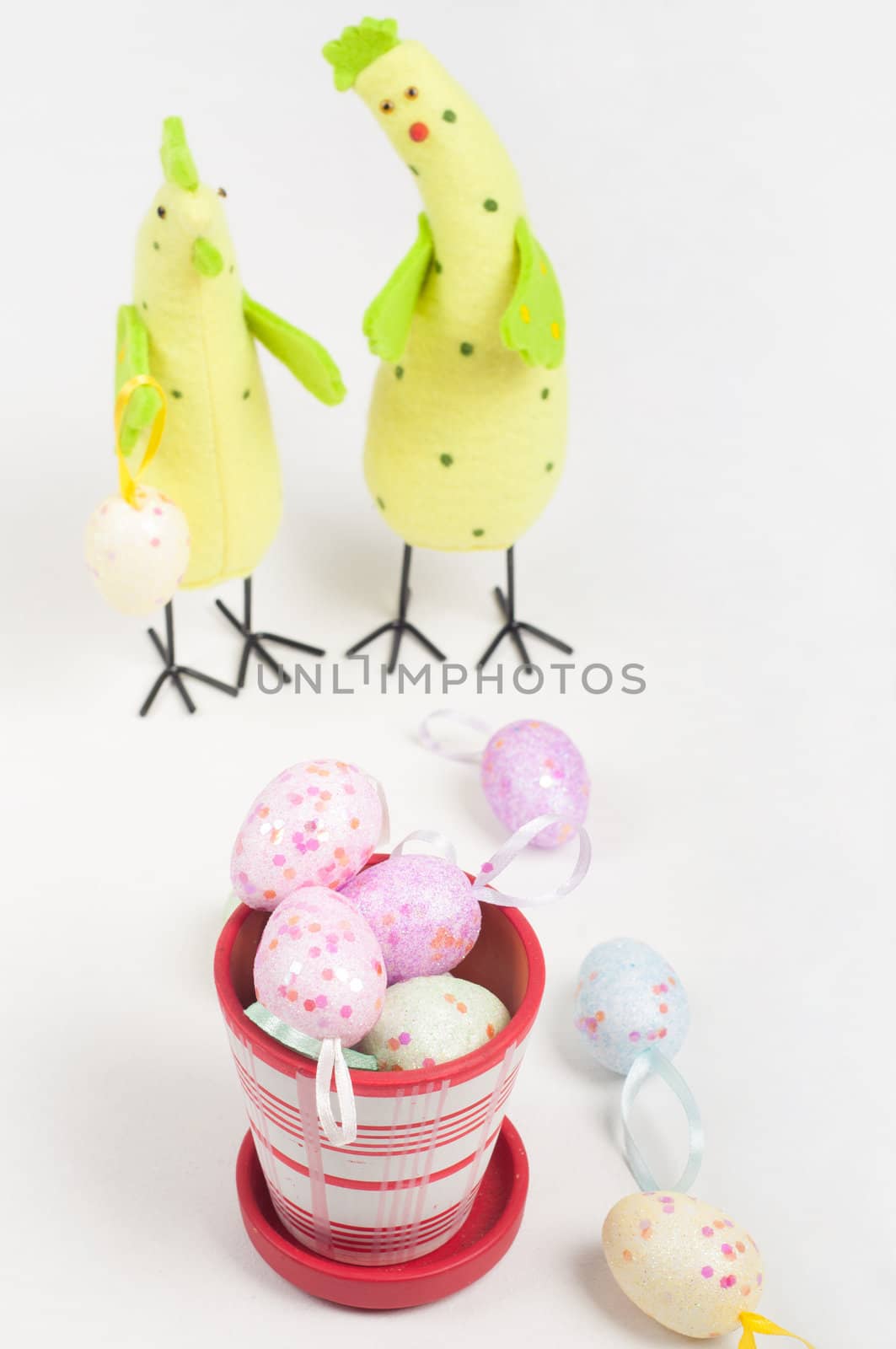Easter chicken family with eggs on flowerpot on light background