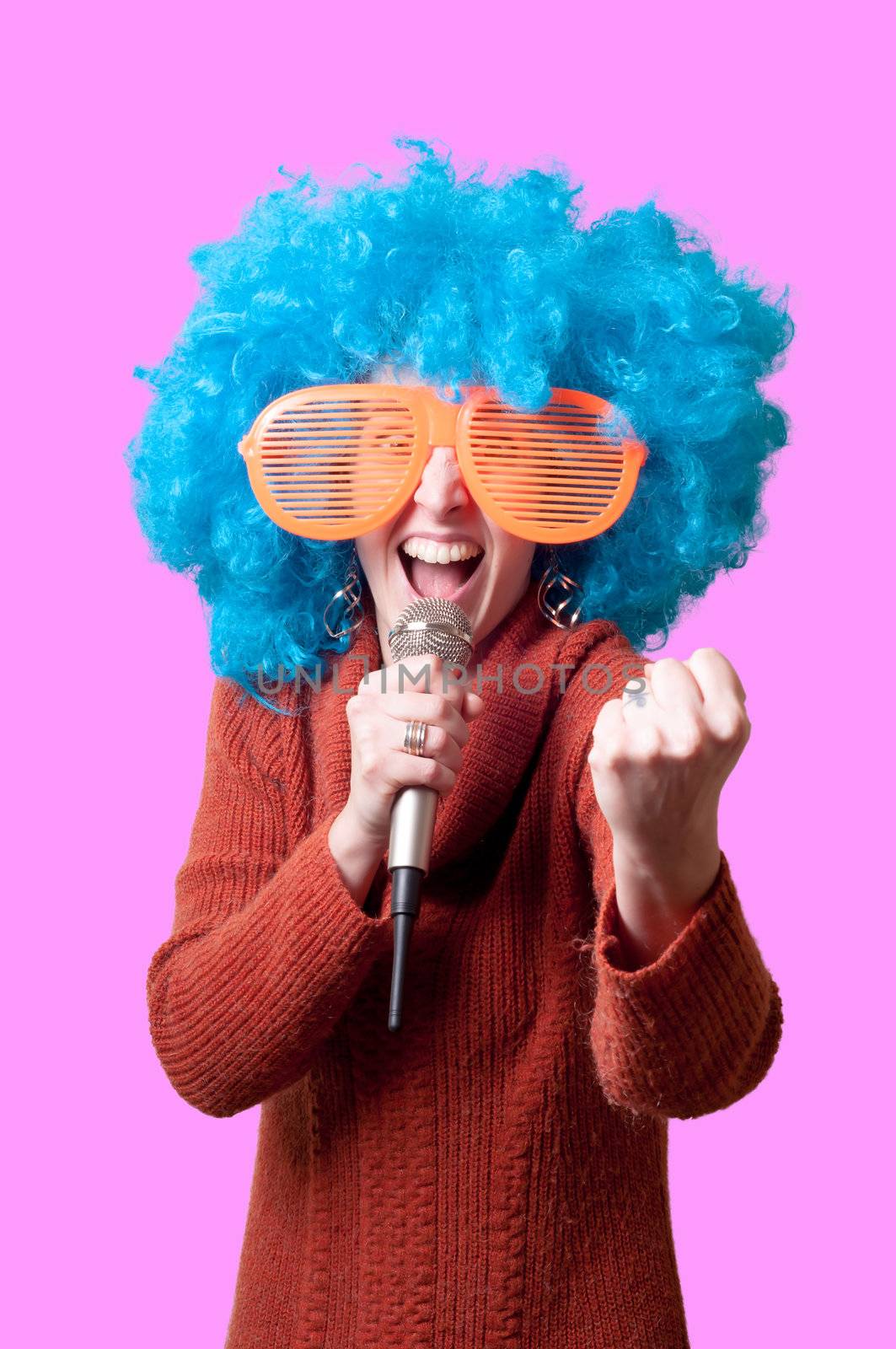 beautiful girl with curly blue wig and turtleneck on pink background