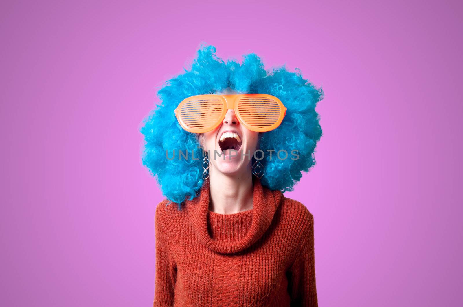 beautiful girl with curly blue wig and turtleneck on pink background