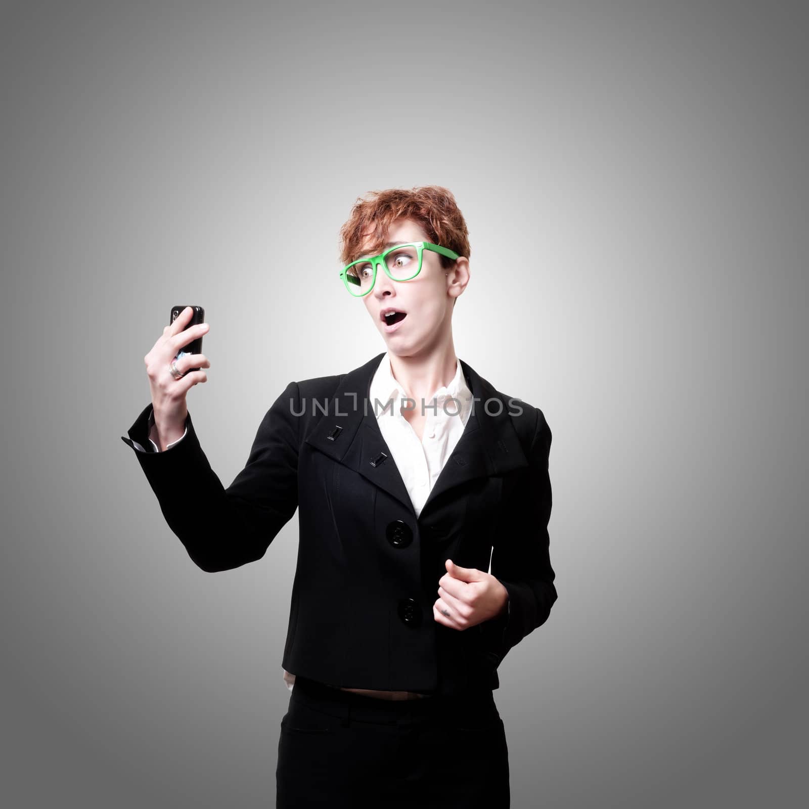 surprised business woman with phone on gray background