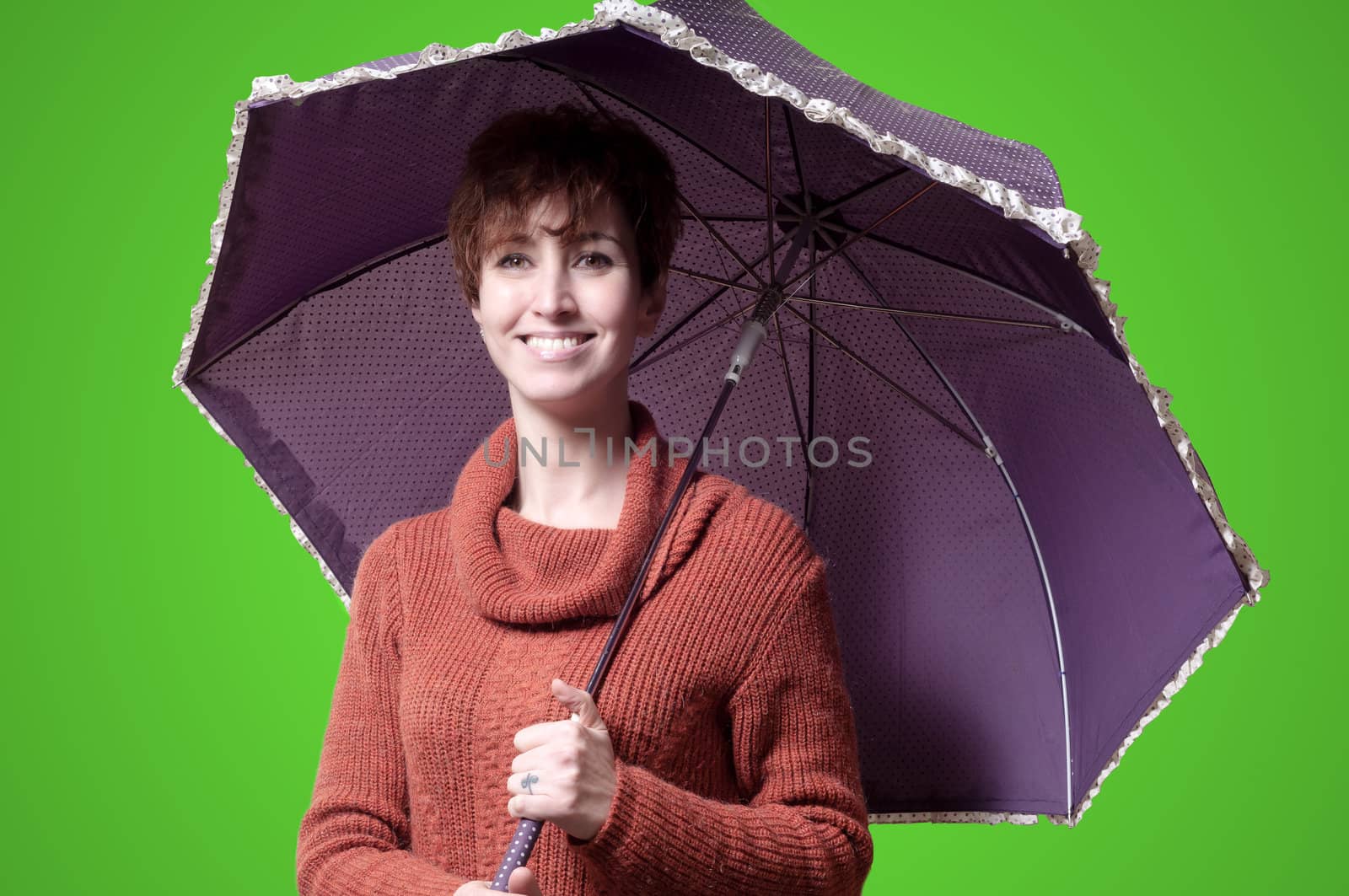 beautiful woman with sweater and umbrella on green background