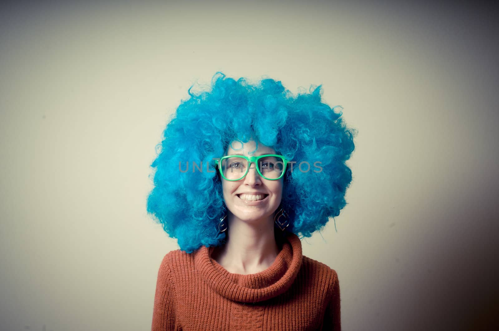 beautiful girl with curly blue wig and turtleneck on white background