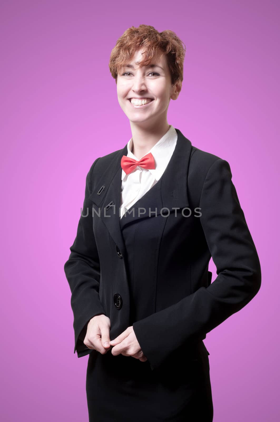 smiling elegant businesswoman with bow tie on pink background