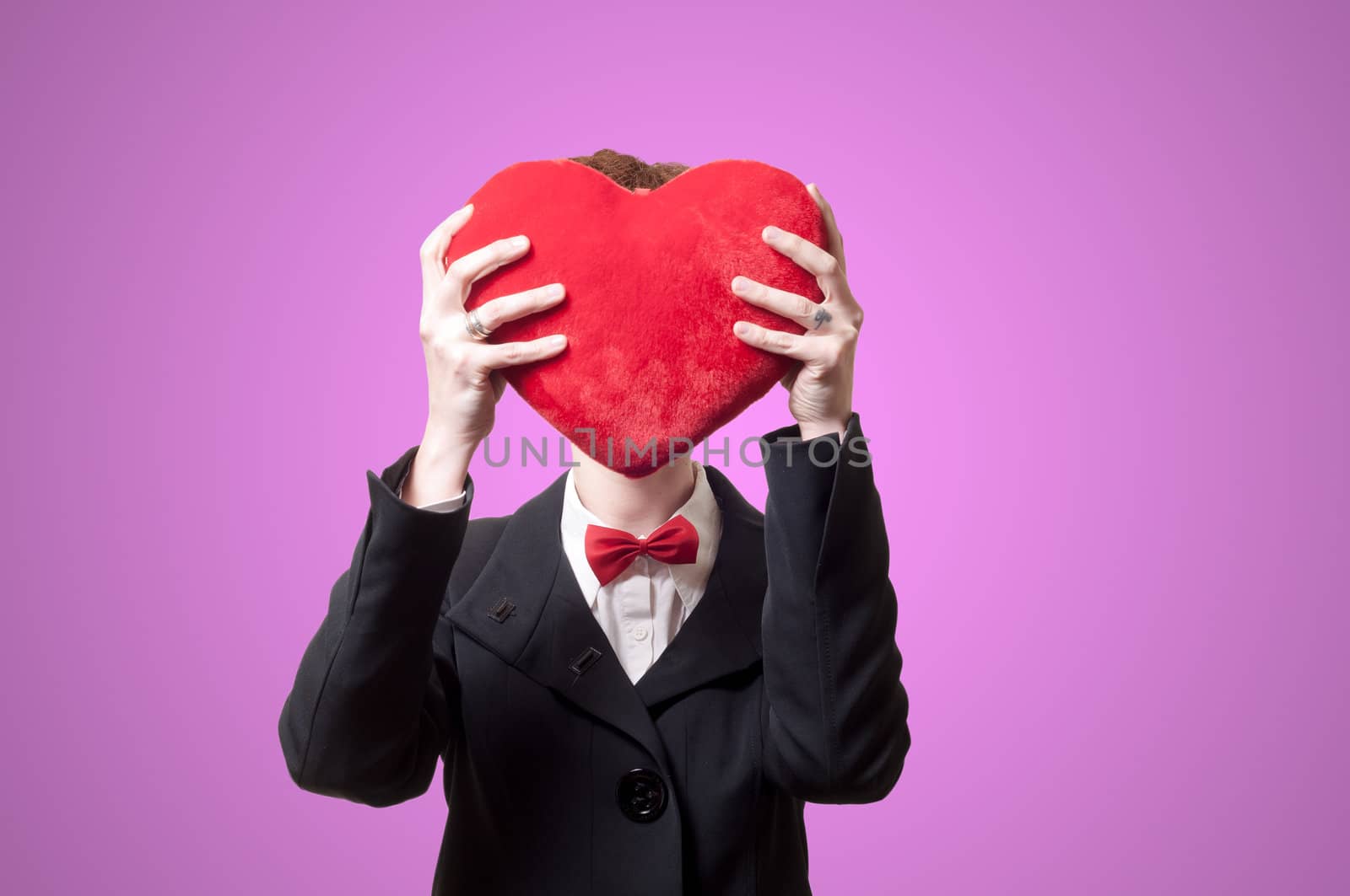 elegant businesswoman with heart pillow on pink background