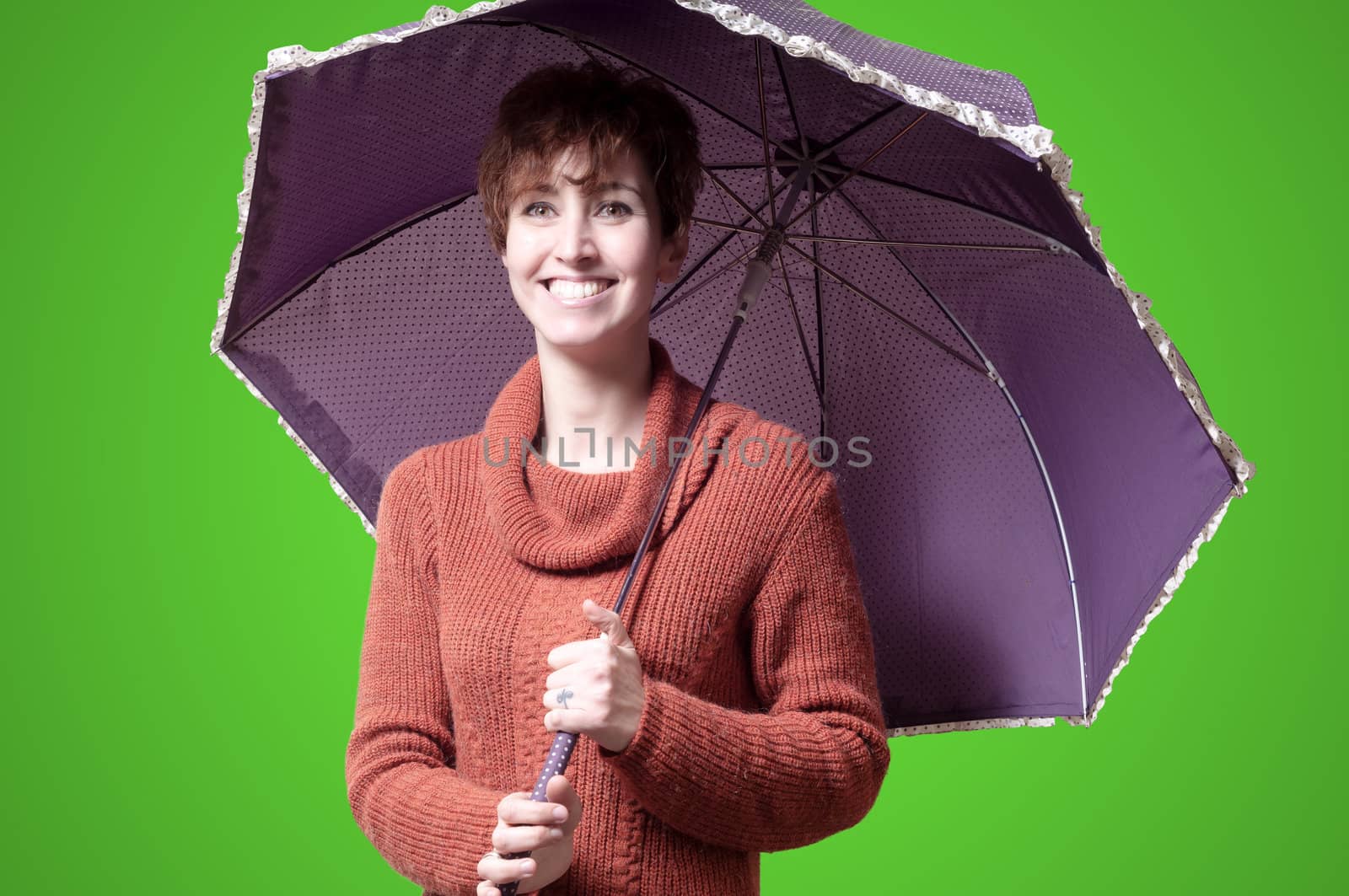 beautiful woman with sweater and umbrella on green background