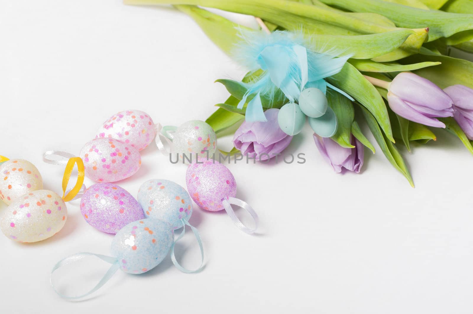 Easter eggs with tulips on light background