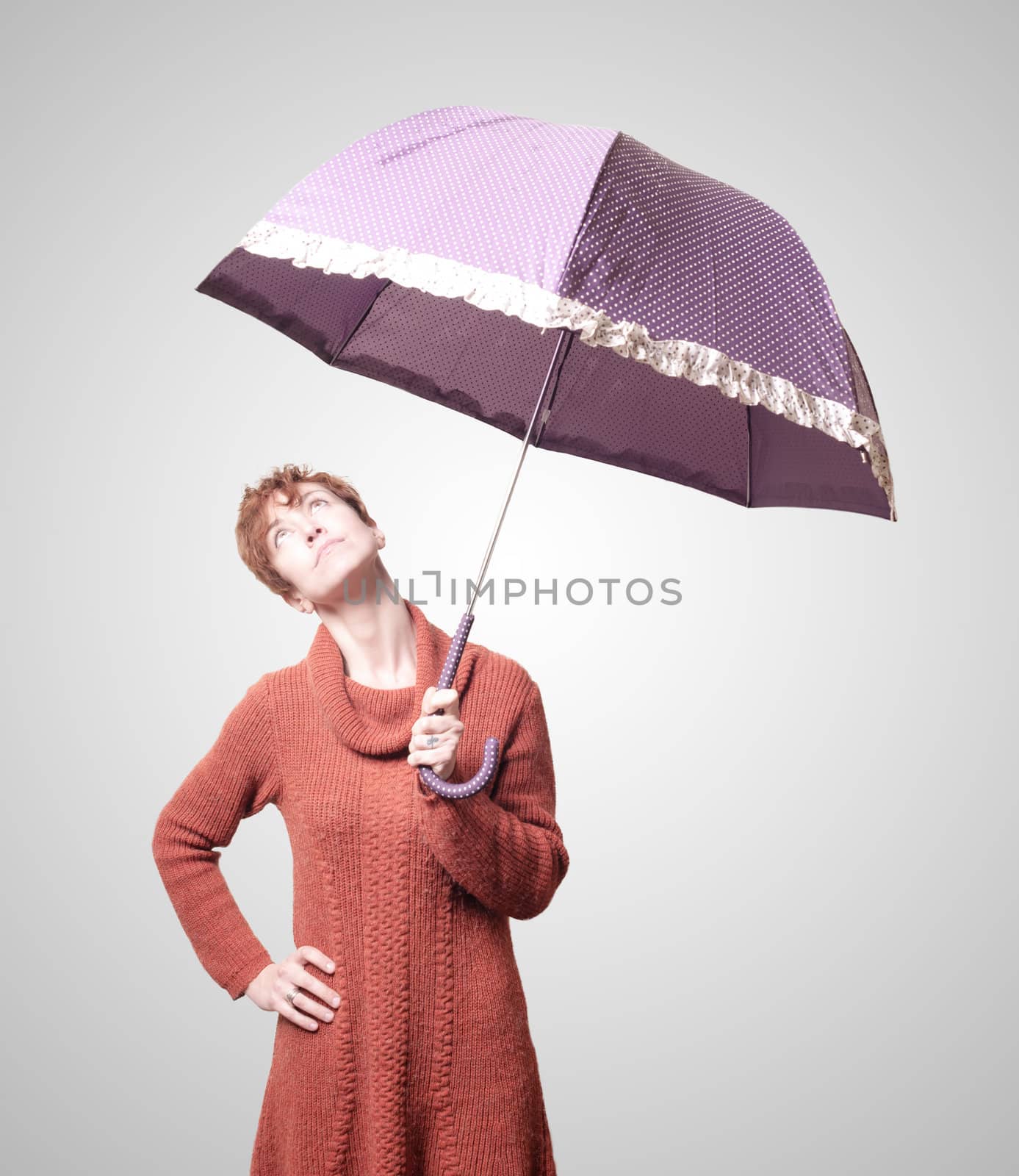 beautiful woman with sweater and umbrella on gray background