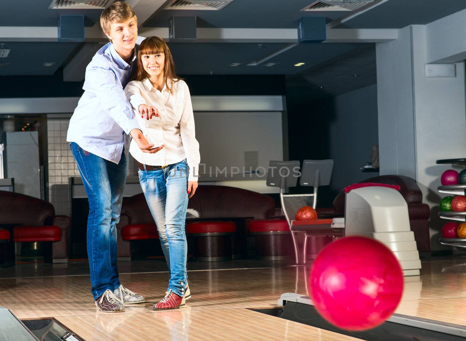 guy hugs her friendgirl, playing together in bowling