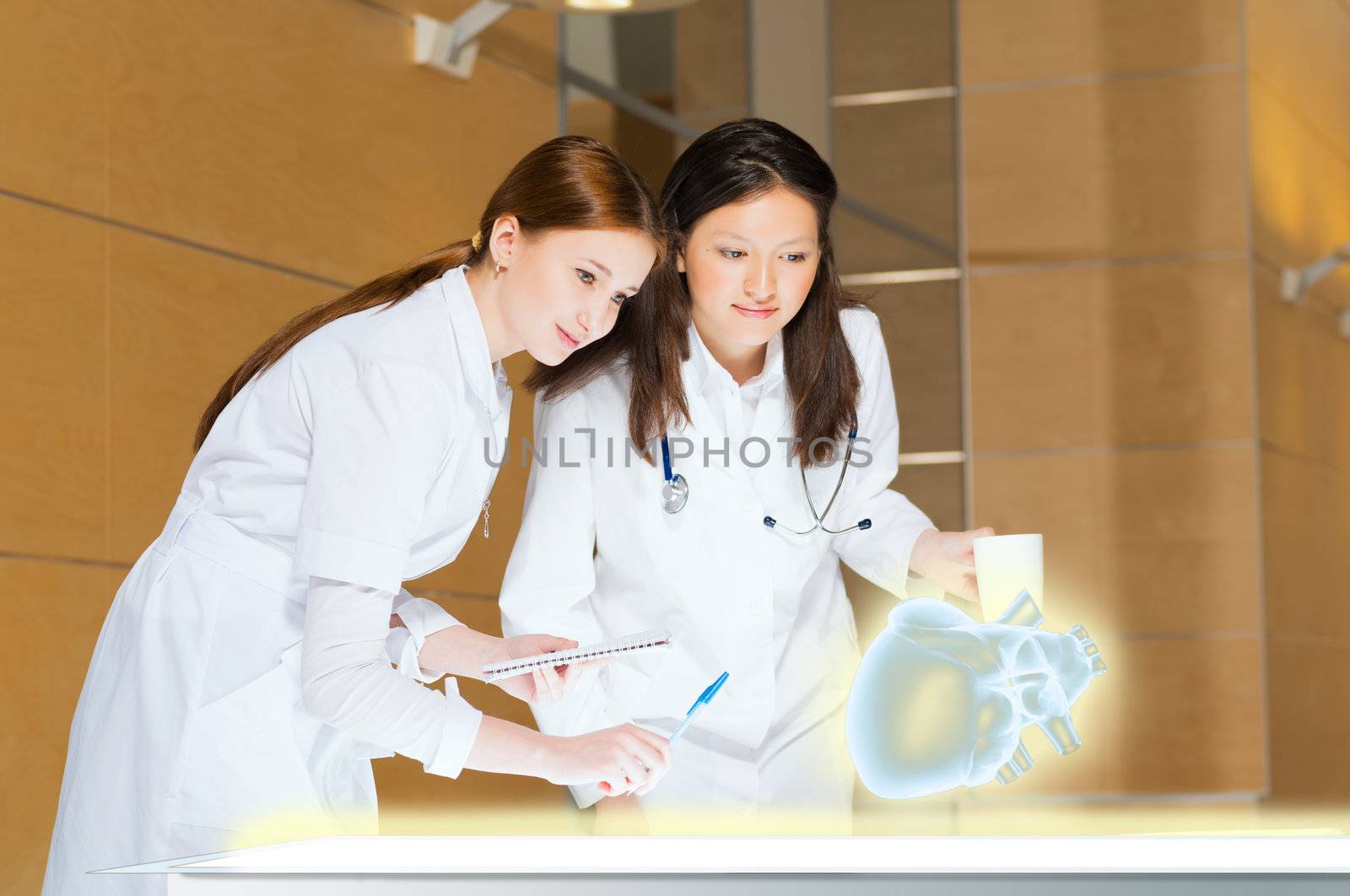 two doctors stand near glowing table discussing. projected objects on a desk