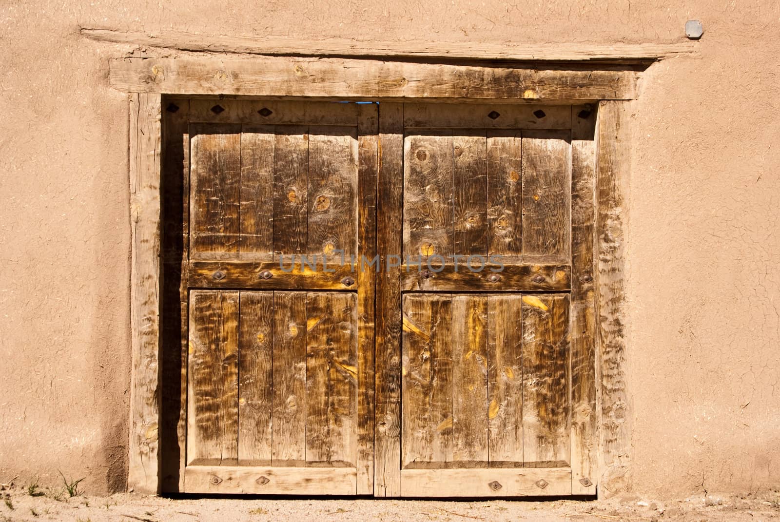 Old door in adobe wall by emattil