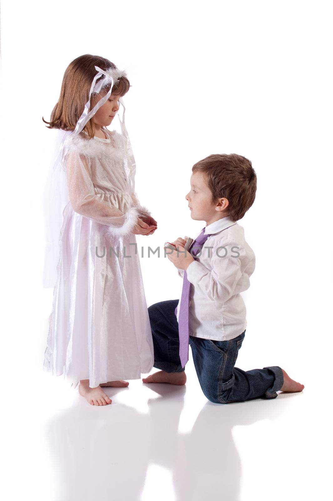 Cute little boy giving an engagement ring to a girl