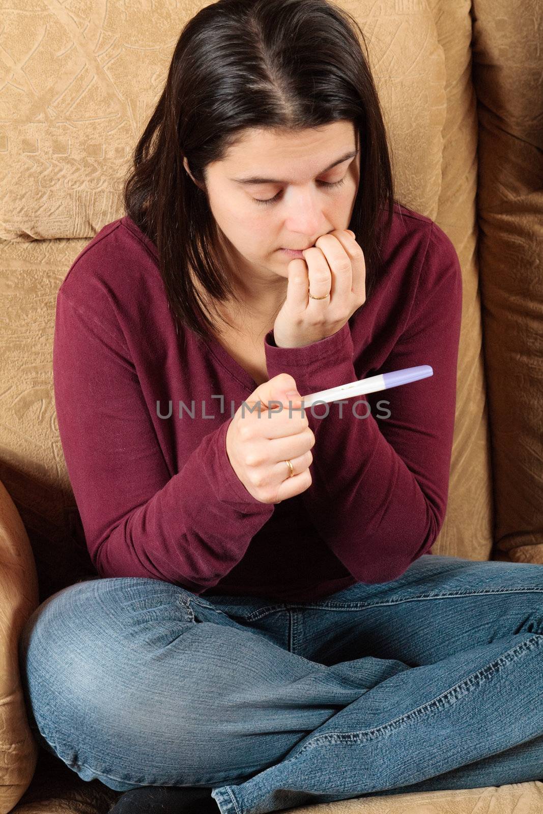 Worried woman holding a pregnancy test