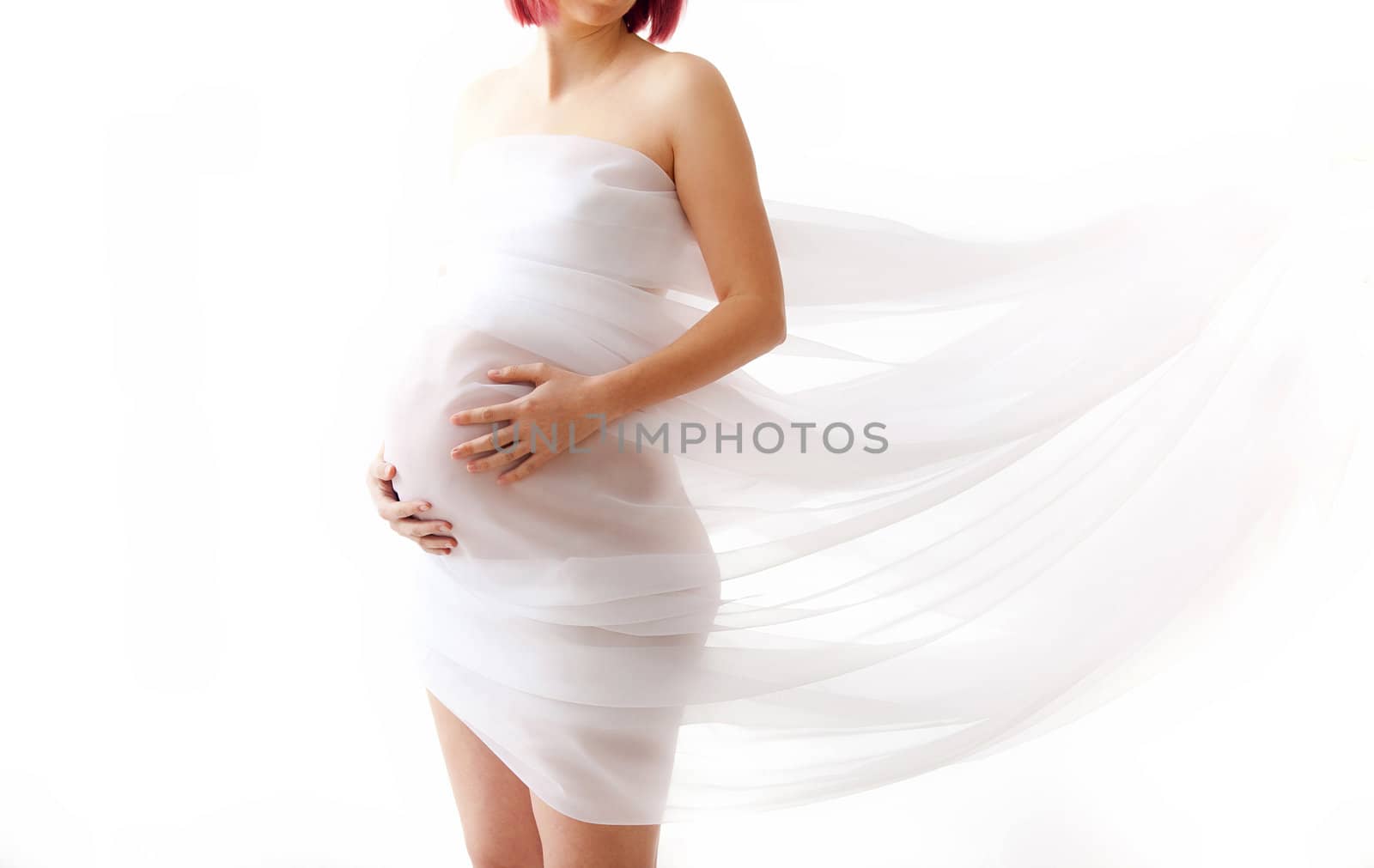 Pregnant woman wrapped in veil holding her belly with arms