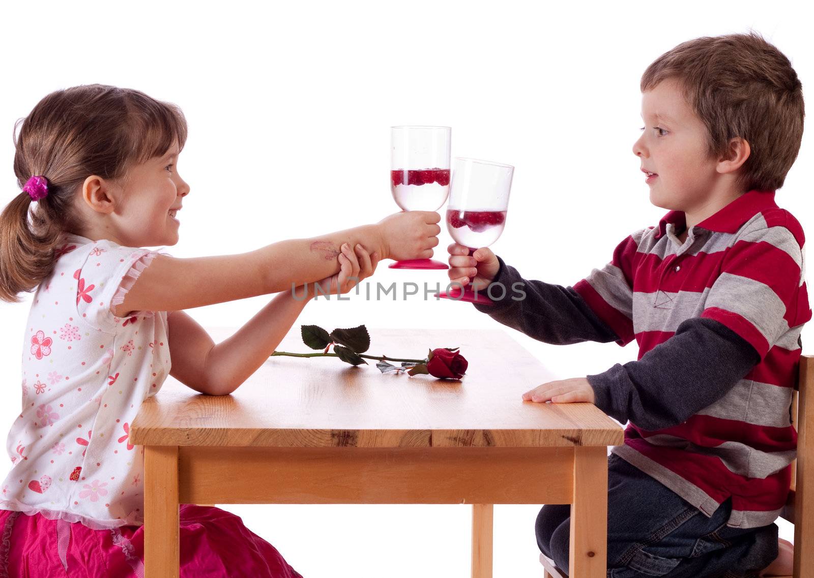 Cute little children making a toast above a red rose