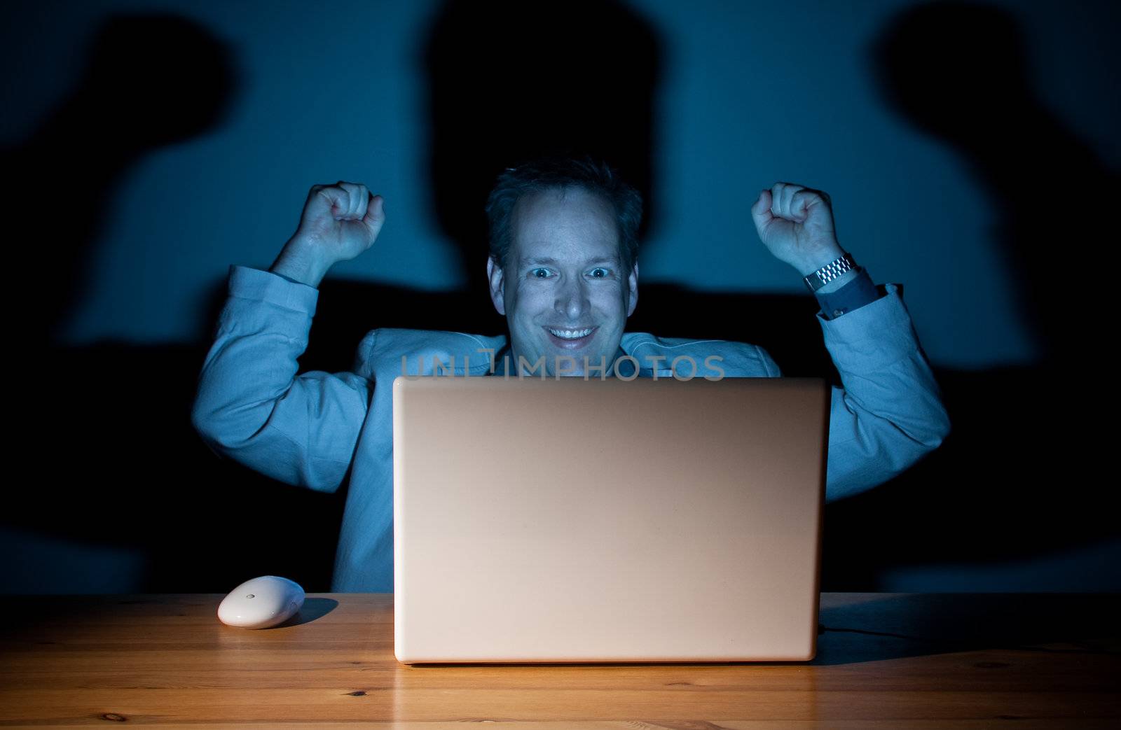 Happy computer guy celebrating late at night