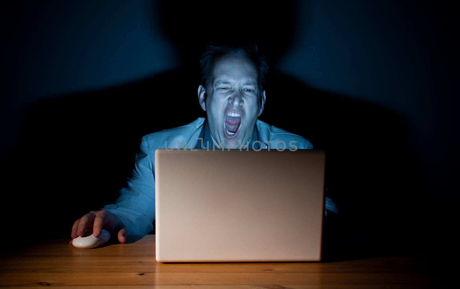 Man yawning in front of his computer