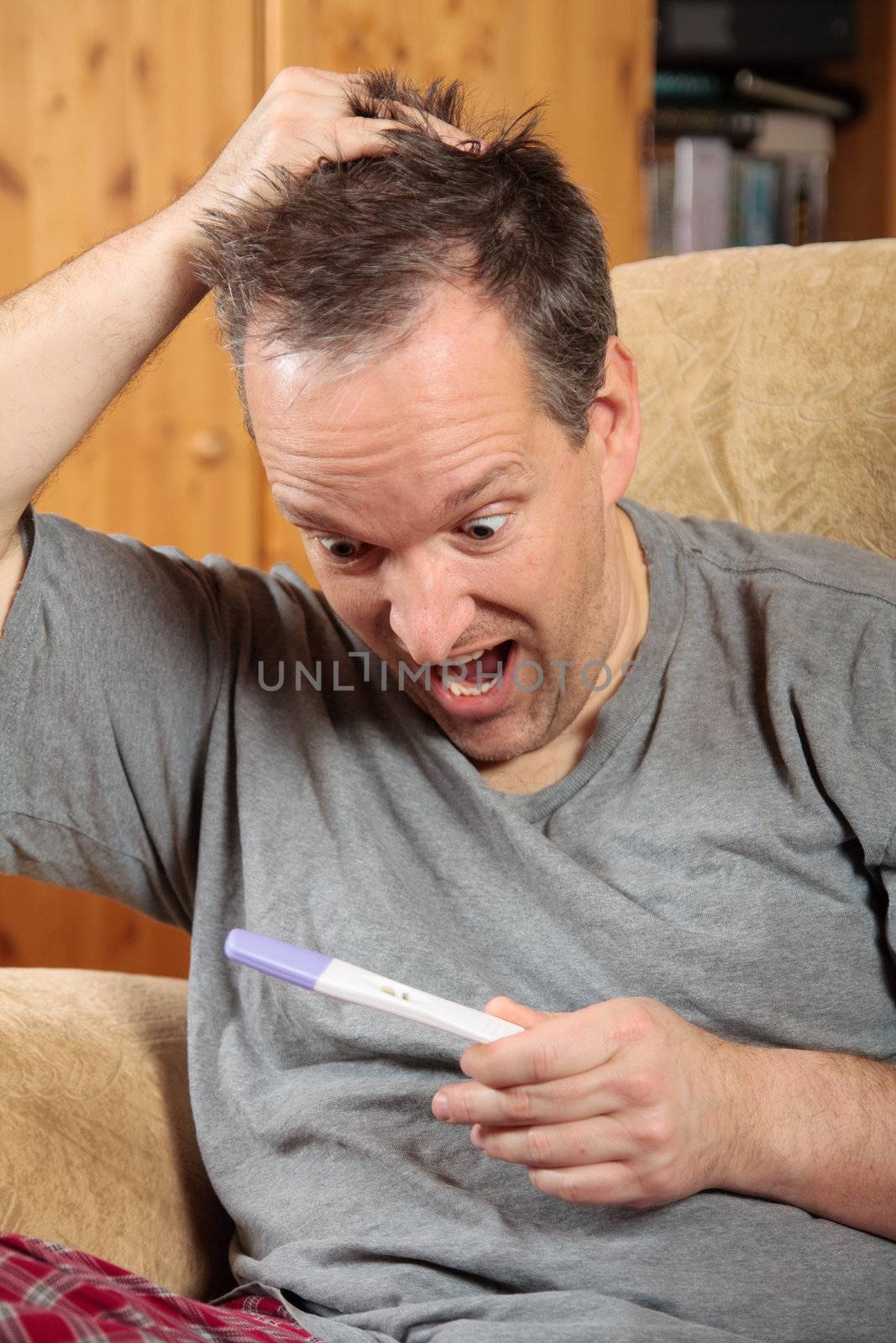 Man holding a pregnancy test by Talanis